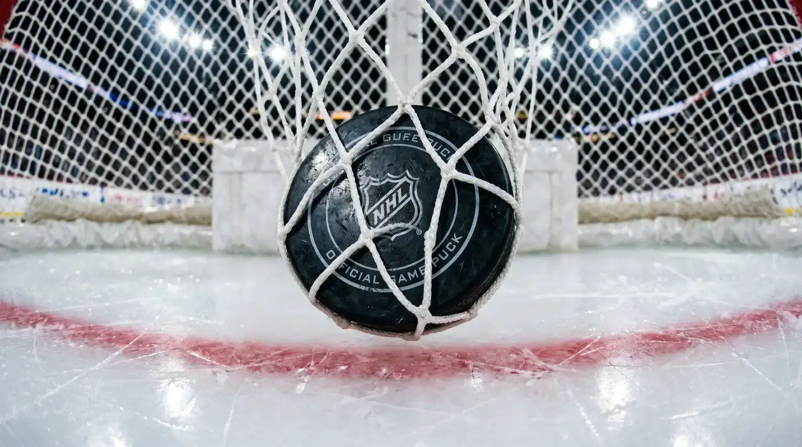 Hockey puck caught in the net mesh after a goal