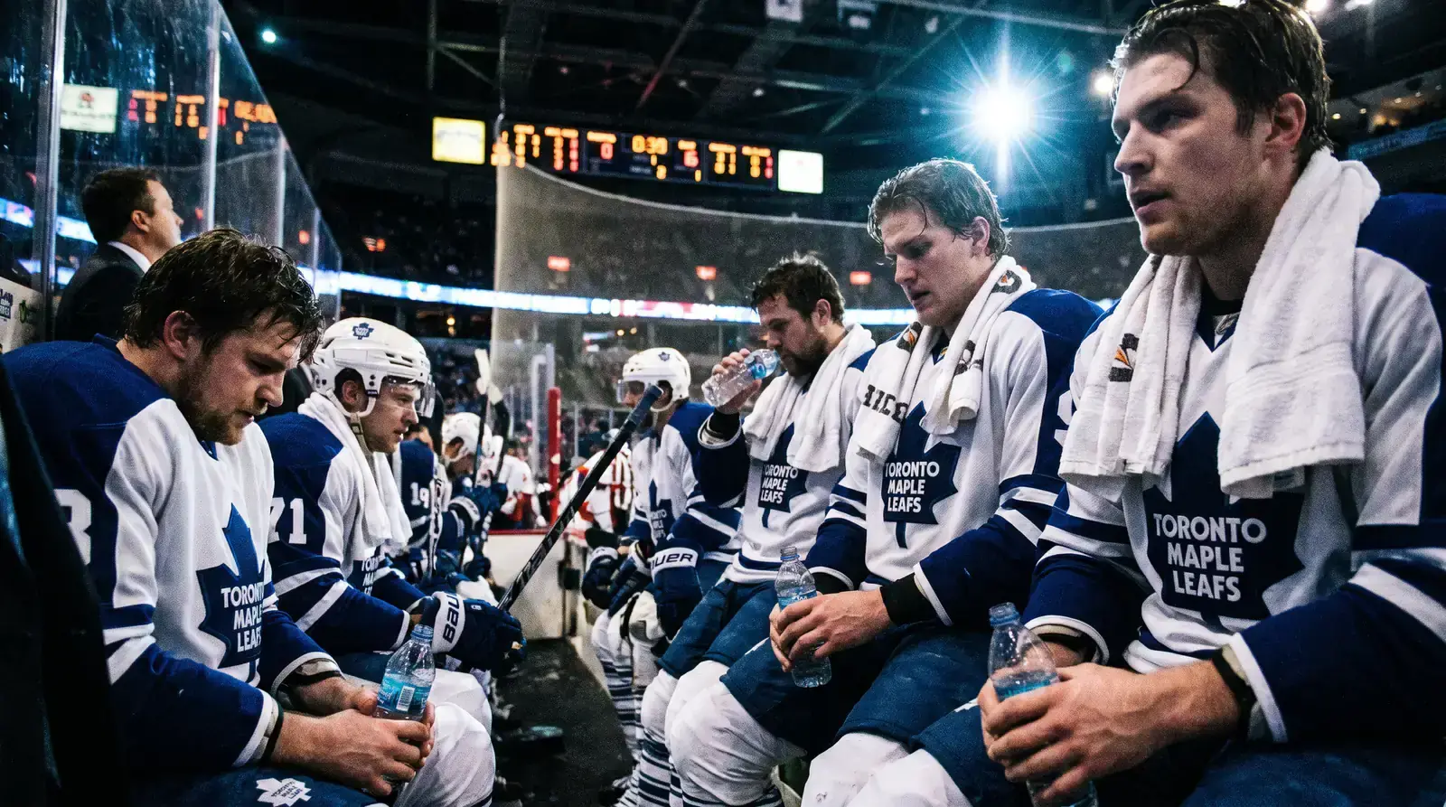 Fatigued NHL players resting on the bench during a back-to-back game